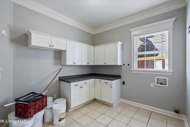 laundry area featuring cabinets, crown molding, washer hookup, and light tile patterned floors