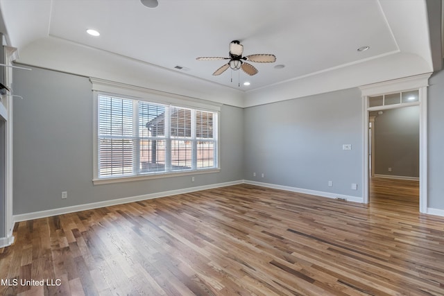 unfurnished bedroom featuring hardwood / wood-style floors, a tray ceiling, and ceiling fan