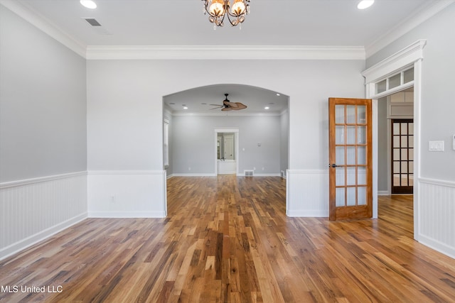 unfurnished room featuring hardwood / wood-style flooring, crown molding, and ceiling fan with notable chandelier