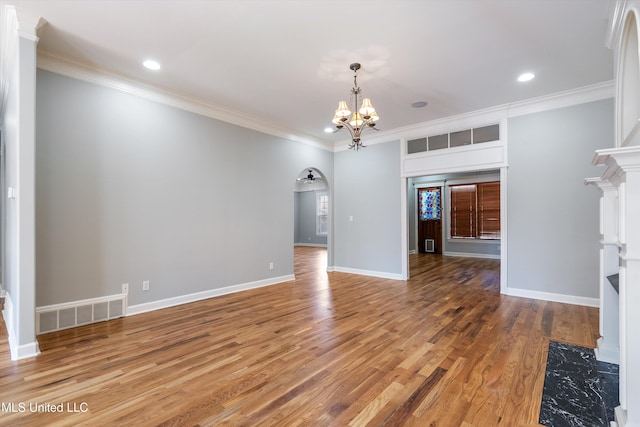 unfurnished living room featuring crown molding, hardwood / wood-style flooring, a premium fireplace, and a chandelier