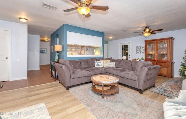 living room featuring ceiling fan and light hardwood / wood-style floors