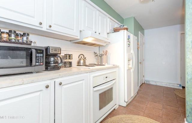 kitchen with decorative backsplash, white cabinetry, light tile patterned flooring, and white appliances