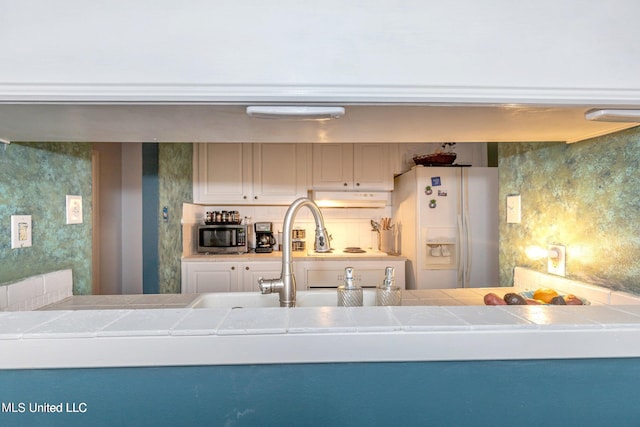 kitchen featuring decorative backsplash and white refrigerator with ice dispenser