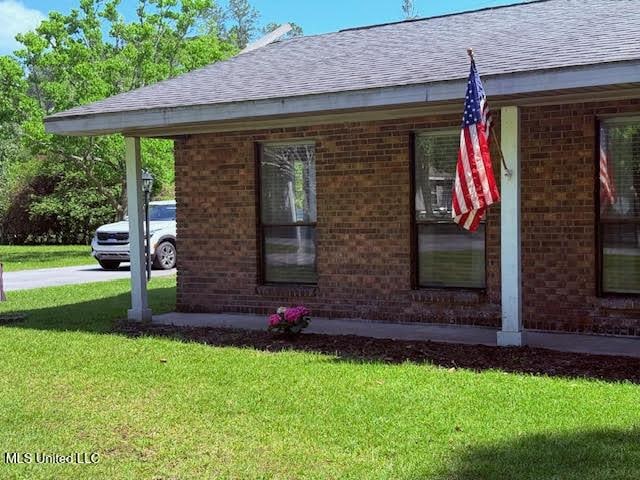 3620 Cochran Ave, Moss Point, MS 39562 - view of side of property featuring brick siding, a lawn, and a shingled roof