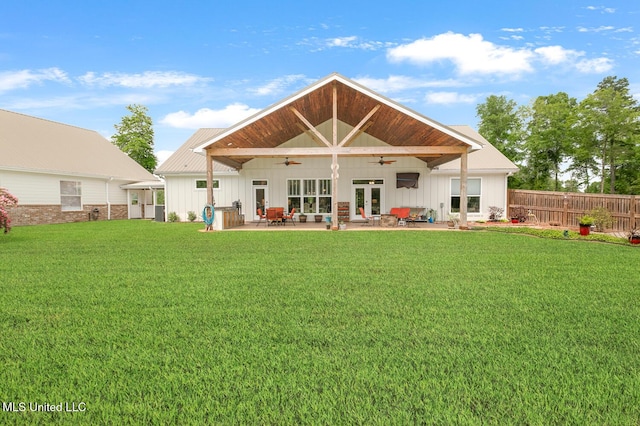rear view of property with fence, a patio area, a ceiling fan, a lawn, and board and batten siding
