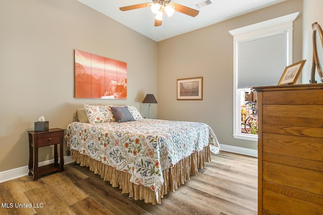 bedroom with baseboards, a ceiling fan, and wood finished floors