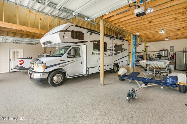 garage with a garage door opener and stainless steel fridge