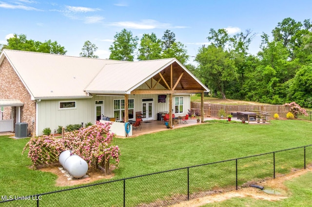 back of property featuring central air condition unit, french doors, a fenced backyard, and a lawn