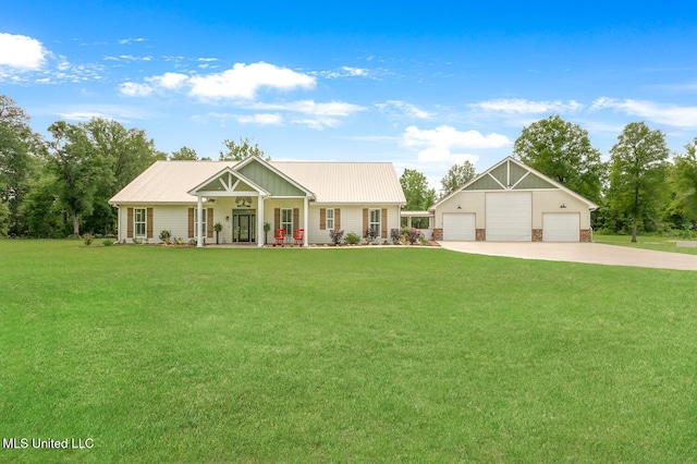 view of front of home with a garage, a porch, a front yard, and an outdoor structure