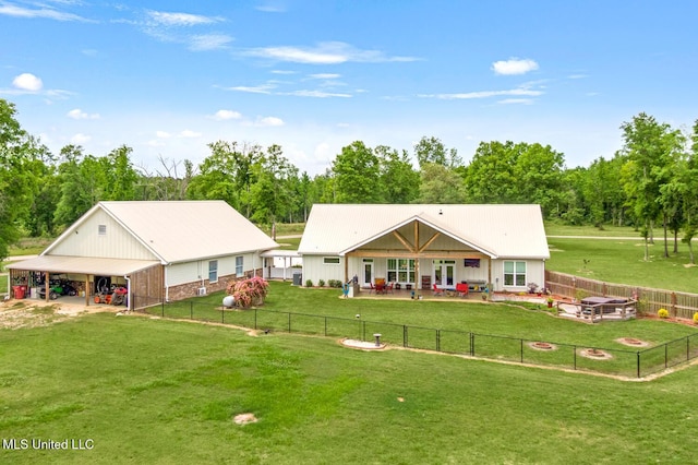 rear view of house featuring a fenced backyard, a lawn, and an outdoor fire pit