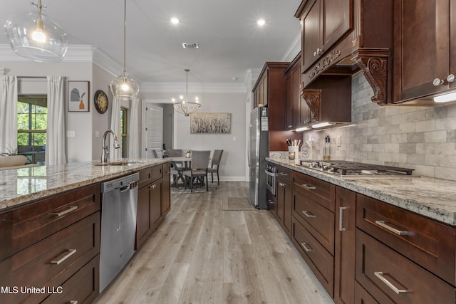 5705 Via Toscana, Ocean Springs, MS 39564 - kitchen featuring appliances with stainless steel finishes, a sink, a chandelier, ornamental molding, and backsplash
