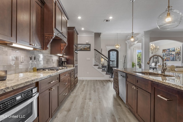 5705 Via Toscana, Ocean Springs, MS 39564 - kitchen with arched walkways, appliances with stainless steel finishes, a sink, crown molding, and tasteful backsplash