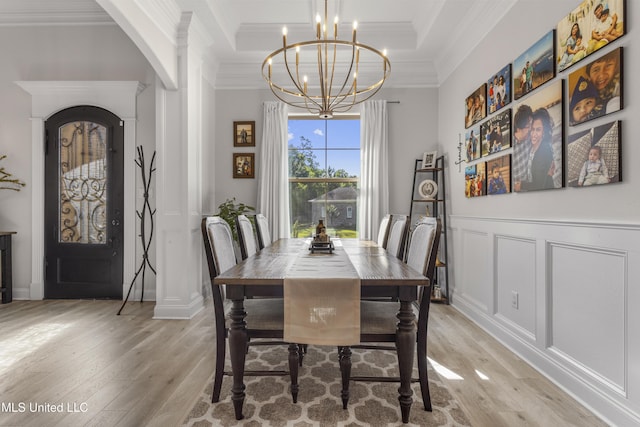 5705 Via Toscana, Ocean Springs, MS 39564 - dining room featuring light wood-style floors, crown molding, a chandelier, arched walkways, and a raised ceiling