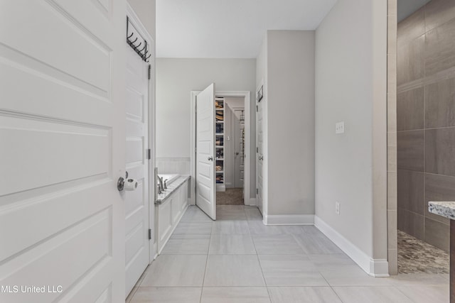 5705 Via Toscana, Ocean Springs, MS 39564 - bathroom featuring a walk in shower, a walk in closet, baseboards, and tile patterned flooring
