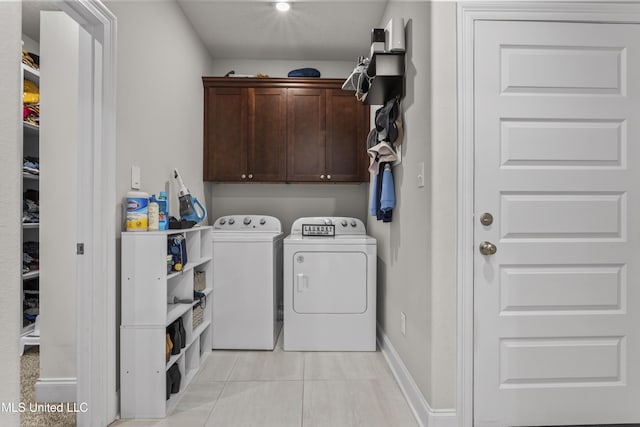 5705 Via Toscana, Ocean Springs, MS 39564 - washroom with washing machine and dryer, cabinet space, baseboards, and light tile patterned flooring