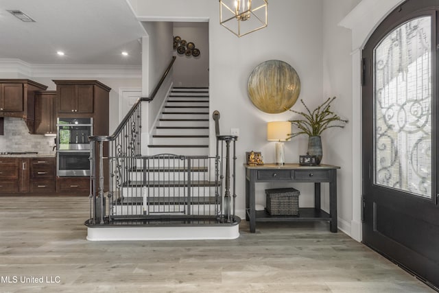 5705 Via Toscana, Ocean Springs, MS 39564 - entrance foyer with stairway, plenty of natural light, light wood-type flooring, a chandelier, and ornamental molding