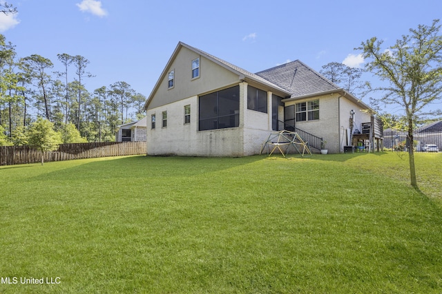 5705 Via Toscana, Ocean Springs, MS 39564 - rear view of house featuring a sunroom, brick siding, a shingled roof, and stucco siding