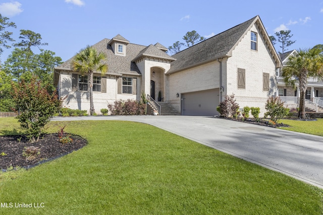 5705 Via Toscana, Ocean Springs, MS 39564 - view of front of home with brick siding, a shingled roof, driveway, and a front lawn