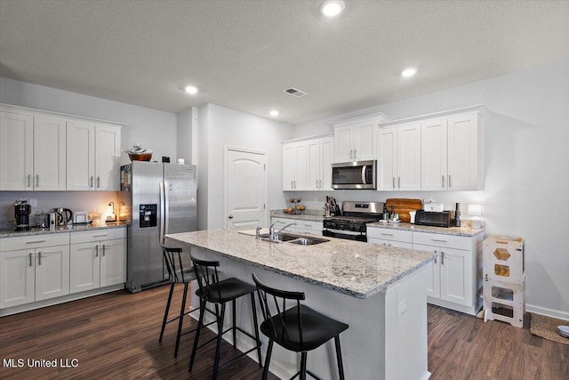 2250 Hyacinth Ln, Hernando, MS 38632 - kitchen featuring appliances with stainless steel finishes, dark wood-style flooring, a kitchen breakfast bar, white cabinets, and recessed lighting