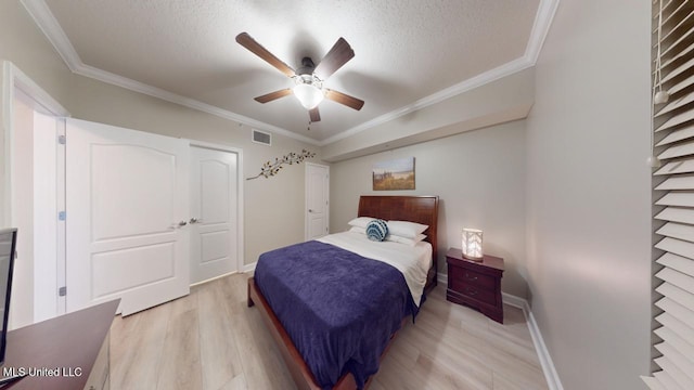 bedroom with crown molding, a textured ceiling, and light wood-type flooring