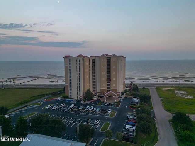 aerial view at dusk featuring a water view