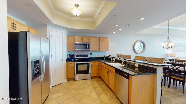 kitchen with a tray ceiling, decorative light fixtures, kitchen peninsula, and appliances with stainless steel finishes