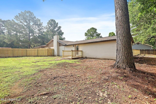 606 Black Oak Cir, Pearl, MS 39208 - back of property with a fenced backyard, a chimney, and a deck