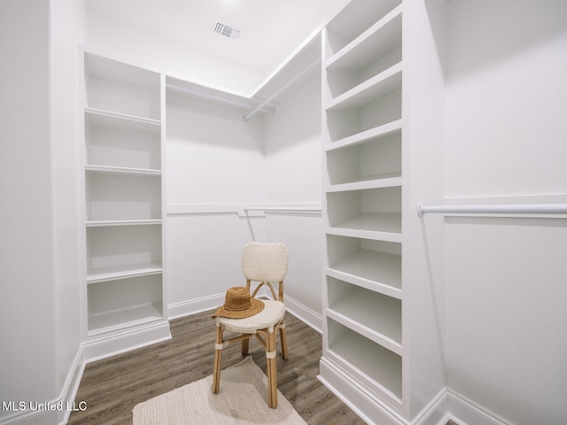 spacious closet featuring dark wood-type flooring and visible vents