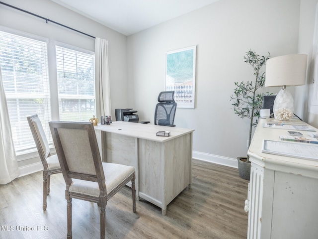 home office with baseboards and wood finished floors