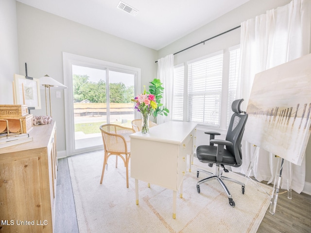 office area featuring visible vents, baseboards, and wood finished floors