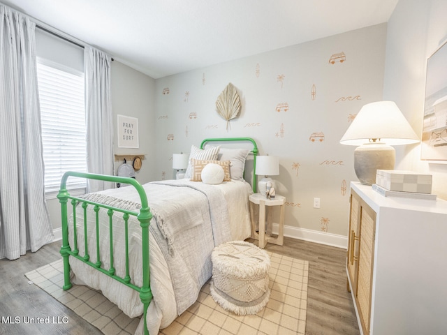 bedroom with light wood finished floors and baseboards