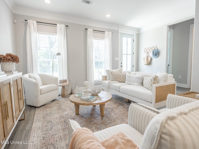 living room with light wood finished floors, baseboards, visible vents, crown molding, and recessed lighting