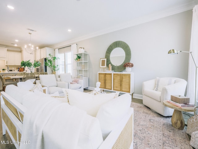 living area with a notable chandelier, recessed lighting, light wood-style flooring, ornamental molding, and baseboards