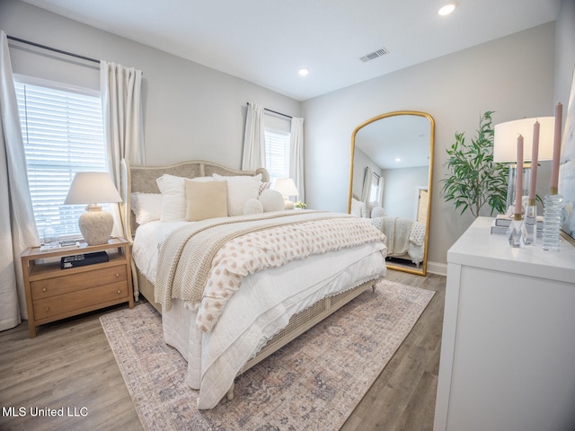 bedroom featuring light wood-style floors, recessed lighting, visible vents, and baseboards