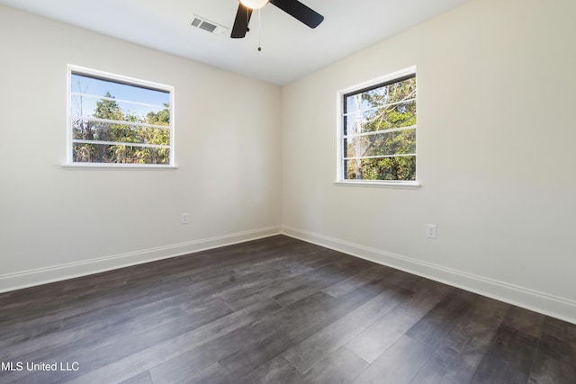 empty room featuring ceiling fan, a healthy amount of sunlight, and dark hardwood / wood-style floors