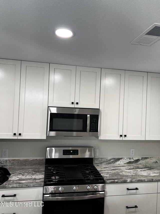 kitchen featuring white cabinetry and appliances with stainless steel finishes