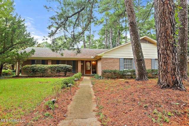 single story home featuring a front lawn and brick siding