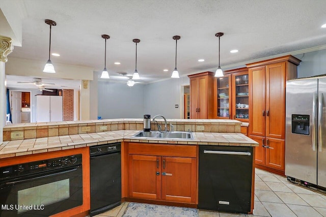 kitchen with tile countertops, black appliances, sink, and pendant lighting