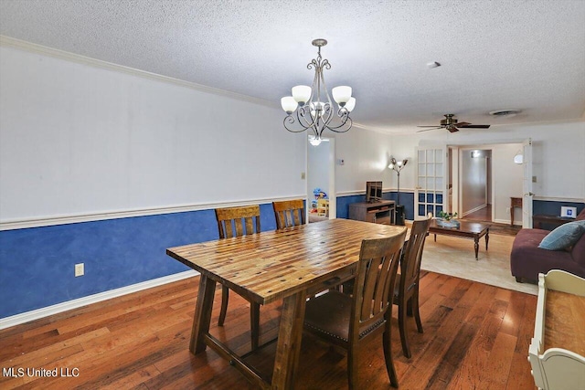 dining room featuring a textured ceiling, ceiling fan with notable chandelier, wood-type flooring, and crown molding