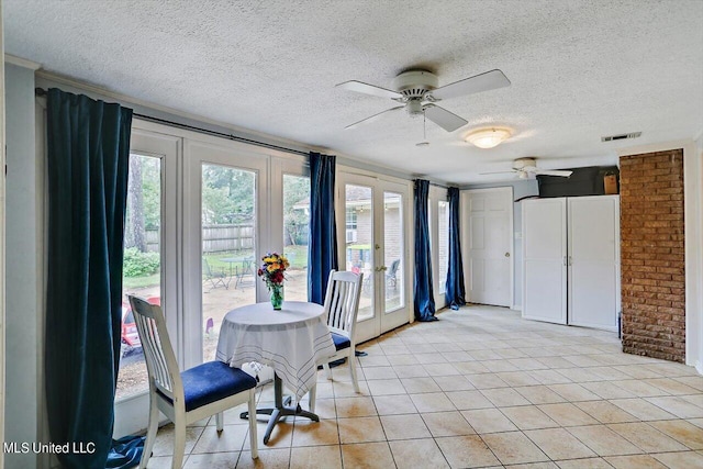 unfurnished dining area featuring light tile patterned flooring, visible vents, a textured ceiling, and french doors