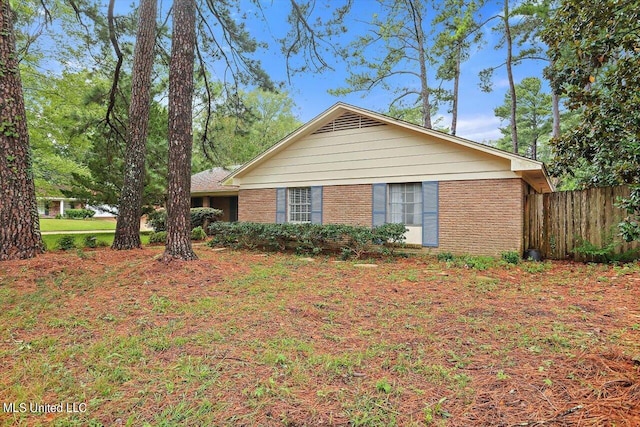 view of front facade featuring fence and brick siding