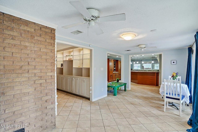 interior space featuring ceiling fan, a textured ceiling, and light tile patterned floors