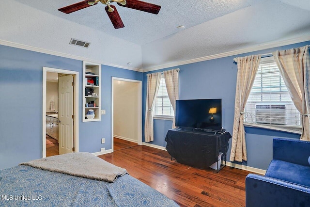 bedroom with wood-type flooring, visible vents, vaulted ceiling, and crown molding