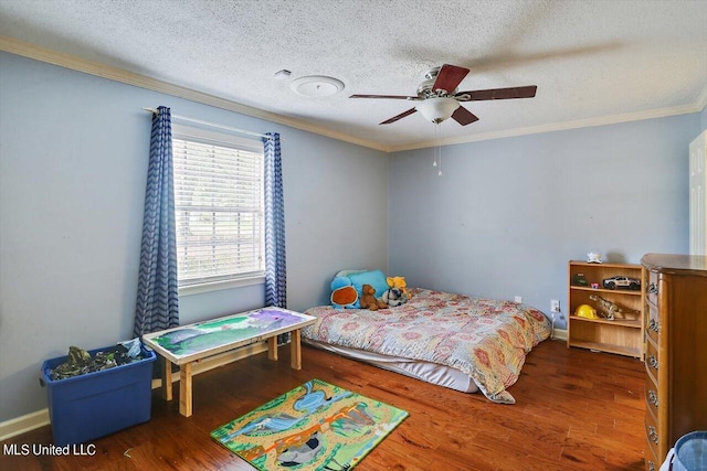 bedroom featuring a textured ceiling, wood finished floors, a ceiling fan, and crown molding