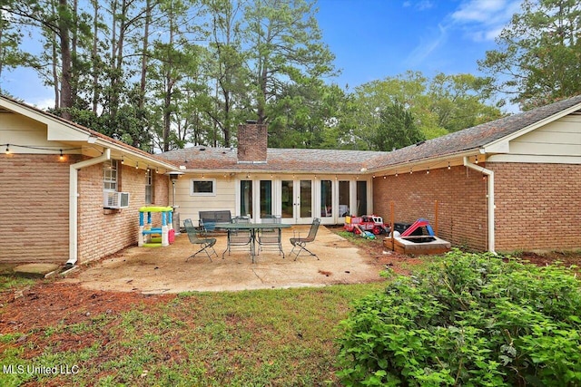 rear view of house featuring a patio, brick siding, a chimney, and cooling unit