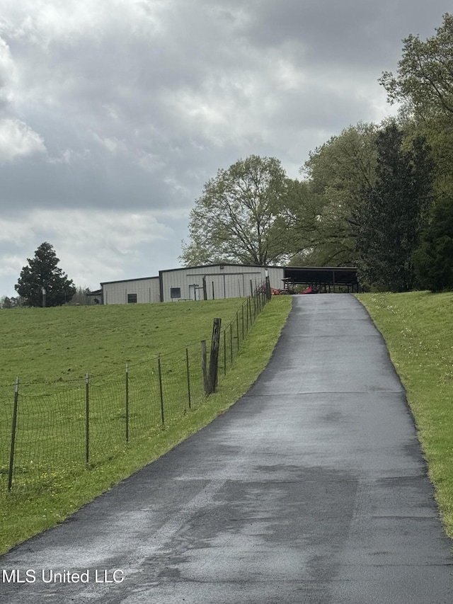 view of asphalt driveway featuring an outbuilding