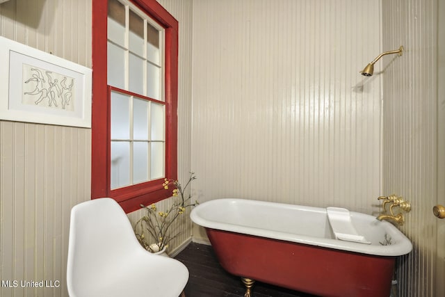 bathroom with hardwood / wood-style floors and a tub to relax in