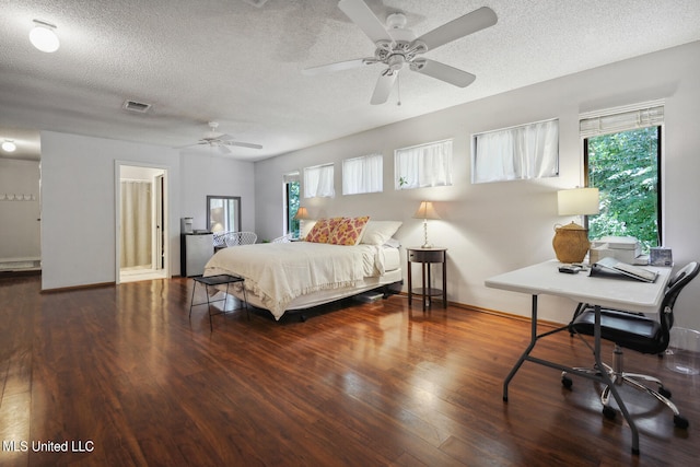 bedroom featuring dark wood-type flooring, a textured ceiling, and ceiling fan