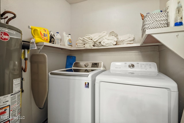 clothes washing area with water heater, separate washer and dryer, and laundry area