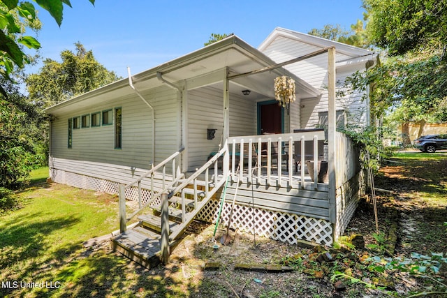 view of front facade with a front lawn and a deck